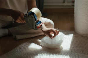 A person packing things into protective materials.