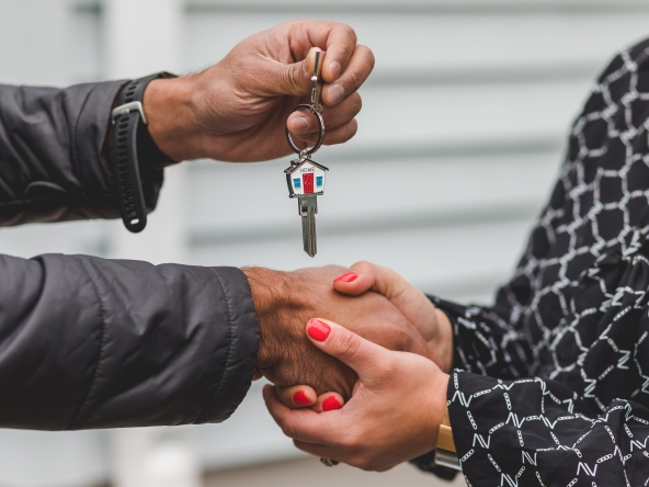 Real estate agent handing over the keys to a new home to their client.