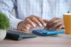 A person using a blue calculator.