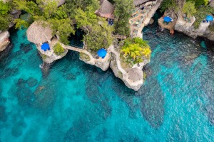 huts on a cliff near blue water