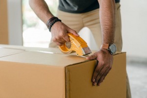 A man sealing a cardboard box